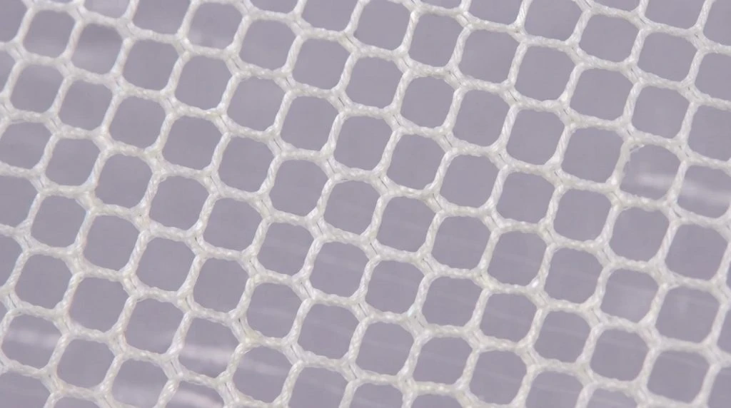 Close-up photograph of the weave of white mosquito net mesh